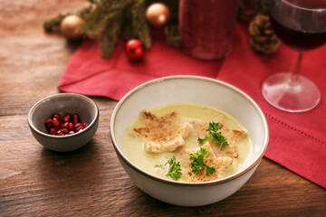 Holiday cream soup with croutons in star shape, parsley garnish and pomegranate seeds, Christmas...