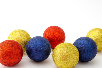 Christmas balls blue, red and yellow color on white background. Selective focus, copy space.