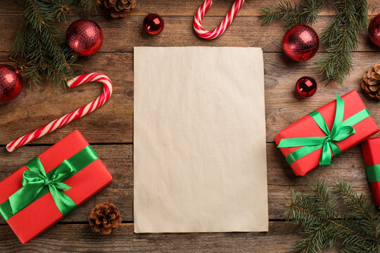 Flat lay composition with paper and Christmas decor on wooden table. Writing letter to Santa Claus