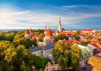 Scenic Tallinn summer cityscape with Saint Olav's church and old town walls and towers at sunset,...