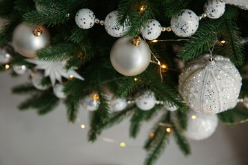 Beautiful Christmas tree decorated with festive lights and baubles indoors, closeup