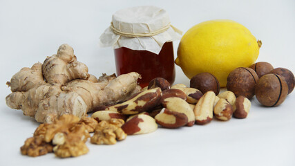 Honey lemon ginger and walnuts, macadamia, and Brazil nuts on a white background