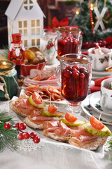 Christmas table with mini canapes and sliced ham and meats