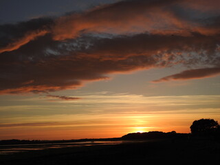 Sunset over the bay and a large artistic cloud