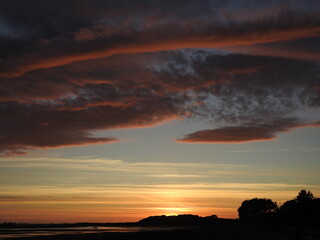 Sunset over the bay and a large artistic cloud