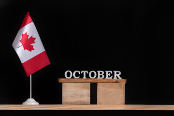 Wooden calendar of October with Canadian flag on black background. Autumn holidays in Canada