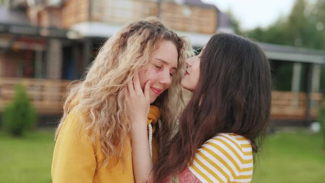 Portrait of two happy women in love. Asian girl kissing her girlfriend with a scar on her face. Body positive concept. Victim of car accident accept herself as she is. Friends love each other