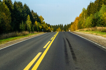  Road with yellow markings and truck wheel brake marks