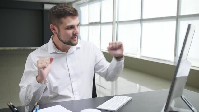 Dancing man sitting at workplace in office