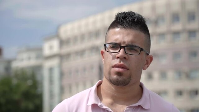 Portrait of a young Jordanian guy with glasses walking around the city.