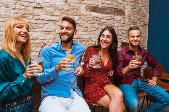 Happy Smiling Friends Drinks Gin Tonic At Night Bar - New Normal Lifestyle Concept With Millennial People Having Fun Together At Home With Alcoholic Beverages. - Focus On Blond Girl