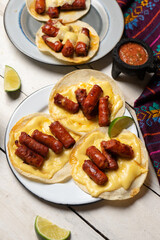 Mexican chistorra tacos with cheese on white background