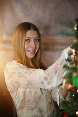 young teen girl decorates the Christmas tree