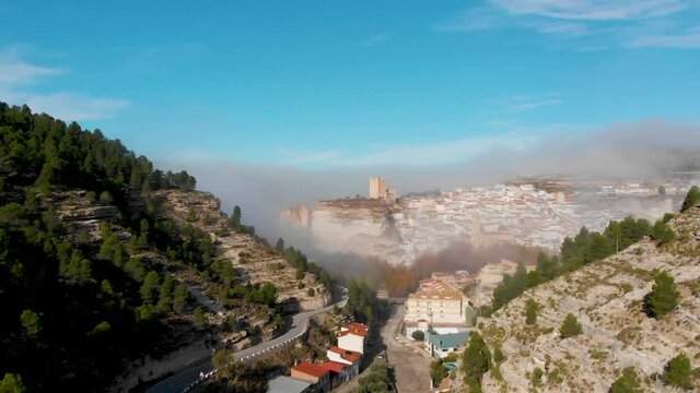 Vista a&eacute;rea de Alcal&aacute; del J&uacute;car, uno de los pueblos m&aacute;s bonitos de Espa&ntilde;a en una ma&ntilde;ana con una m&aacute;gica niebla que envuelve su belleza