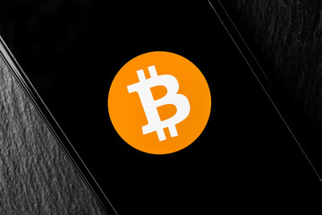 Logo of Bitcoin digital cryptocurrency money on the screen of a smartphone