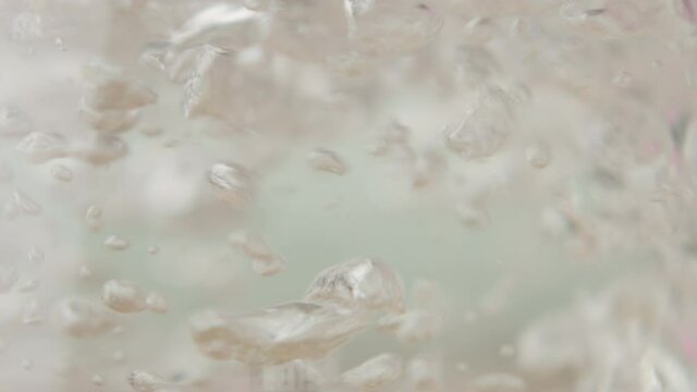A transparent kettle of water boils, slowmo, silver kitchen.