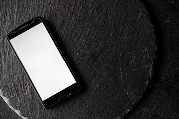 Empty screen of a smartphone with copy space against black slate background