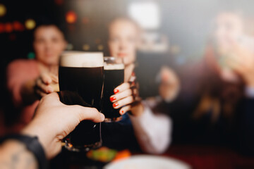 Young group of friends drinking beer, having fun, laughting and celebrating together.