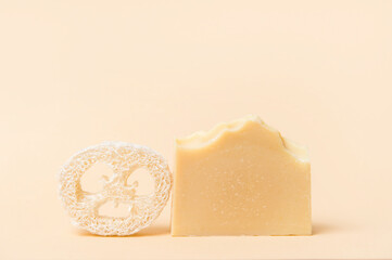 Handmade soap and loofah sponges on a beige background. Eco lifestyle concept...