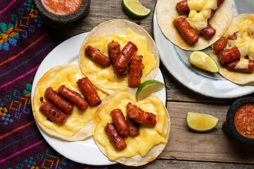 Mexican chistorra tacos with cheese on wooden background
