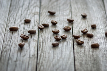 sparse coffee beans on gray wood