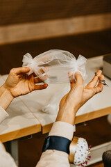 Seamstress sews a bridal face mask for wedding day. Women is working at faberlic to protective masks during the COVID-19 virus pandemic. Fighting the COVID-19 pandemic.