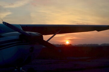 The plane was photographed in the evening, under the wing of which we see the setting sun.