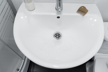 Fototapeta premium Hair loss. Hair in the sink after combing the head