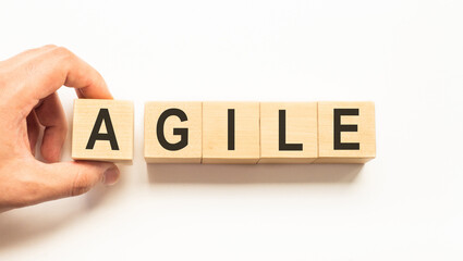 Word agile. Wooden small cubes with letters isolated on white background with copy space available. Business Concept image.