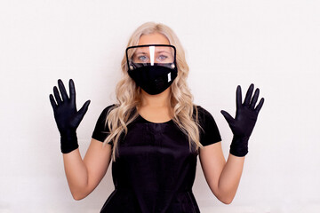 Hairdresser in black professional clothes, face mask and gloves in beauty salon. Safety concept.