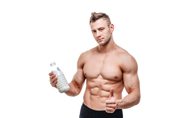 Fototapeta premium a bottle of milk in his hand, a man with sporty body posing on a white background.