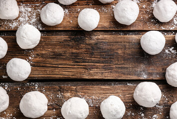 Frame of snowballs on wooden background, flat lay. Space for text