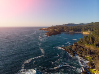 Fototapeta premium Aerial drone panoramic view of rocky cost in the ocean. Beautiful sunny weather. Amazing natural landscape. View from above.