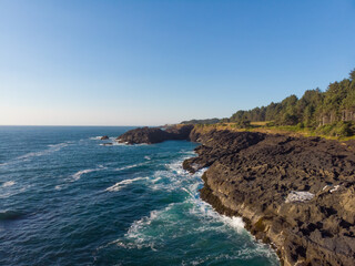 Fototapeta na wymiar Aerial drone panoramic view of rocky cost in the ocean waves. Beautiful sunny weather. Amazing natural landscape. Wallpaper design.
