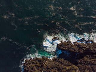 Aerial drone view of ocean waves hugs fantastic rocky coast. Wallpaper design. Amazing landscape. Beautiful view from above. Concept of wild nature.