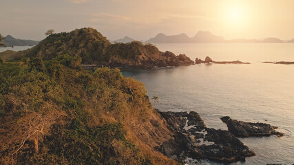 Closeup rock island at sun seascape aerial. Nobody tropic nature landscape with cliff mount in exotic trees and plants. Picturesque panorama of El Nido Islets at summer sunny day