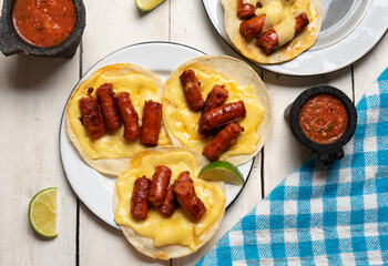 Mexican chistorra tacos with cheese on white background