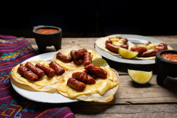 Mexican chistorra tacos with cheese on wooden background