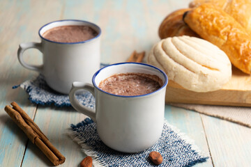 Hot cocoa with cinnamon and bread  on blue background