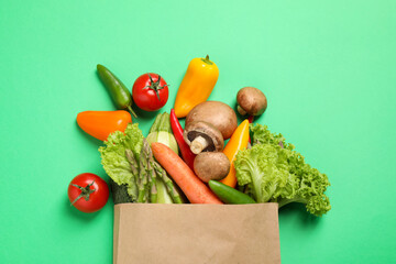 Different fresh vegetables on green background, flat lay