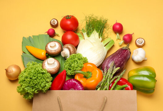 Different fresh vegetables on yellow background, flat lay