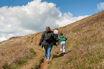 At the clifftop with family enjoying walking above coastline of West Bay on the Jurassic Coast in Dorset. Taken on sunny summer day.