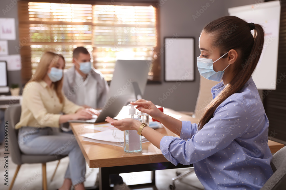 Sticker Office worker using hand sanitizer at table. Personal hygiene during COVID-19 pandemic