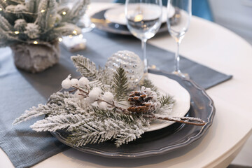 Table with set of dishware and beautiful Christmas decor in kitchen. Interior design
