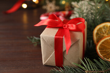 Gift box and Christmas decorations on wooden table, space for text