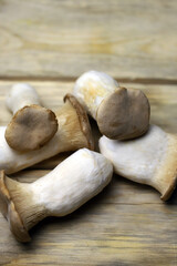 Fresh eringi mushrooms on a wooden surface.