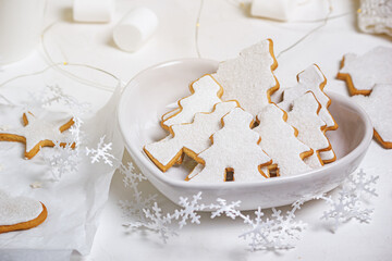 Christmas composition with gingerbread on a white textured surface, close-up view. Christmas celebration concept