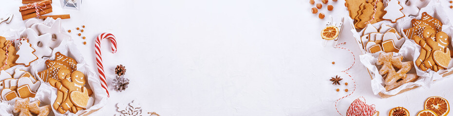 Top view of unpacked christmas presents with sweets on a white textured surface, banner, close-up. Christmas celebration concept with space for text © Nymphalyda