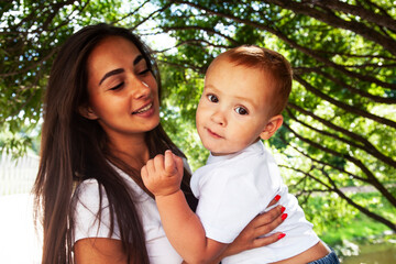 young pretty brunette mother with little cute boy walking in park happy smiling, lifestyle people concept