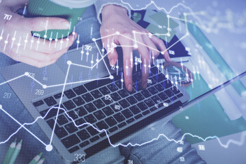 Double exposure of woman hands typing on computer and forex chart hologram drawing. Stock market invest concept.